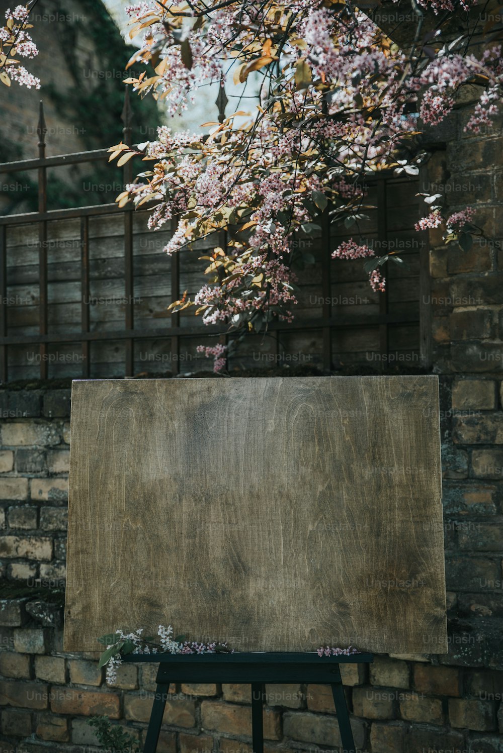 a wooden easel sitting in front of a brick wall