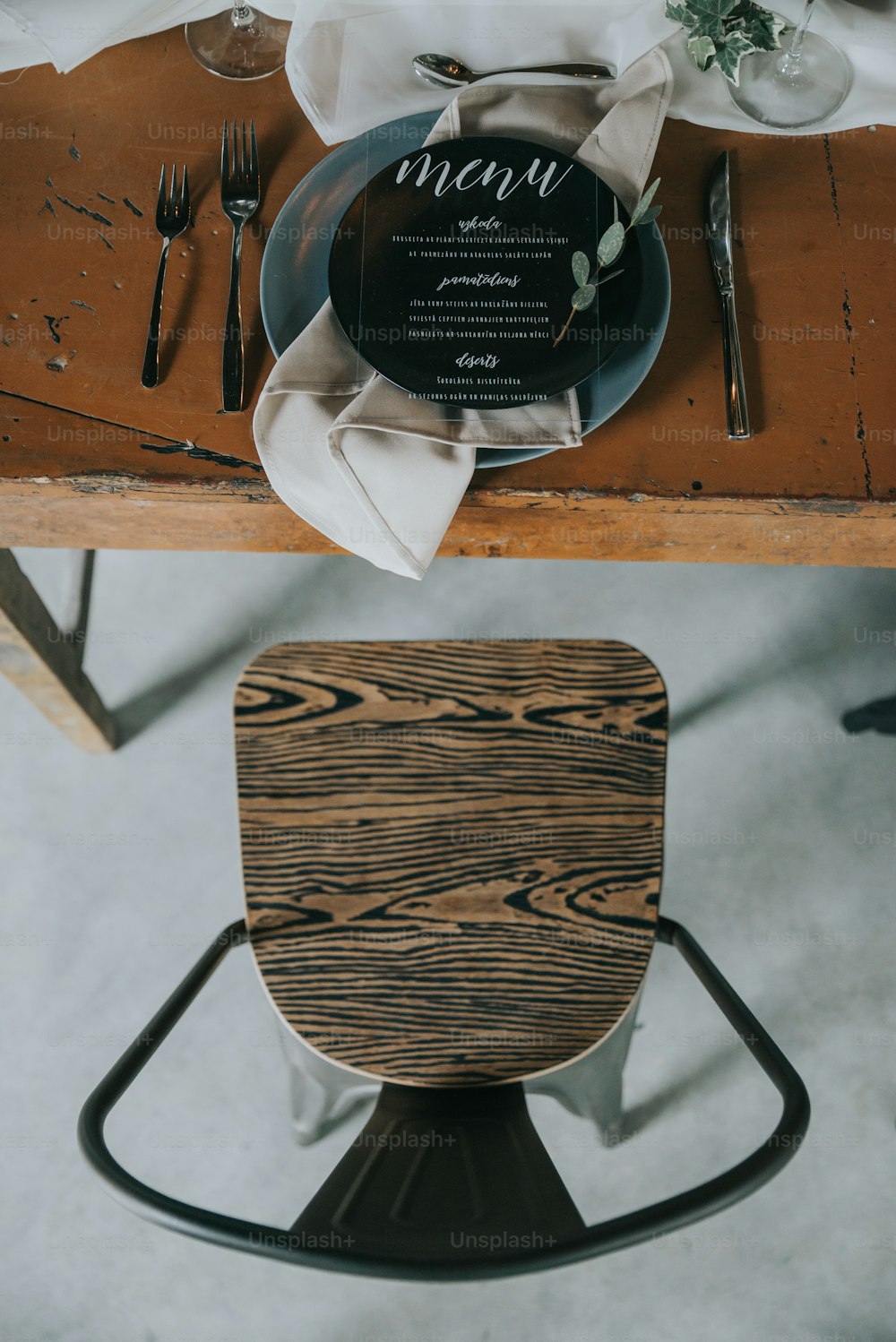 a wooden table topped with a black plate