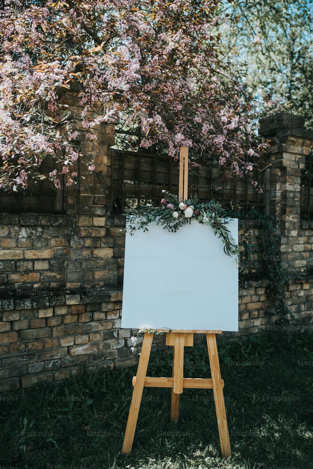 an easel with a white board in front of a brick wall