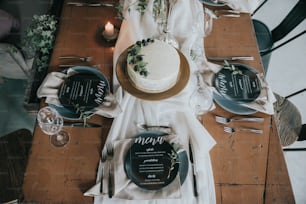a table topped with a cake and plates