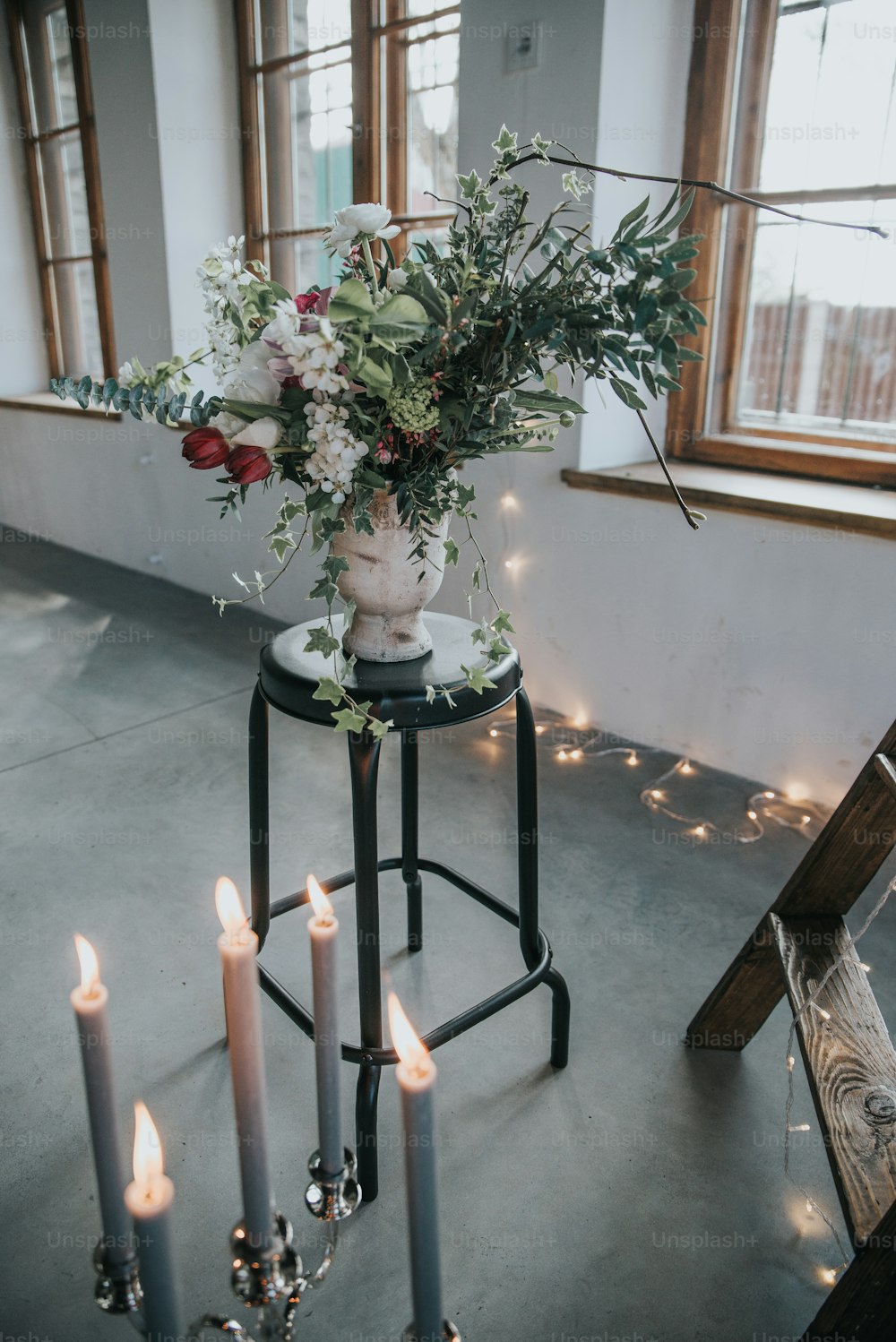 eine Vase mit Blumen auf einem Tisch mit Kerzen