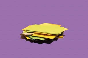 a pile of yellow paper sitting on top of a purple surface