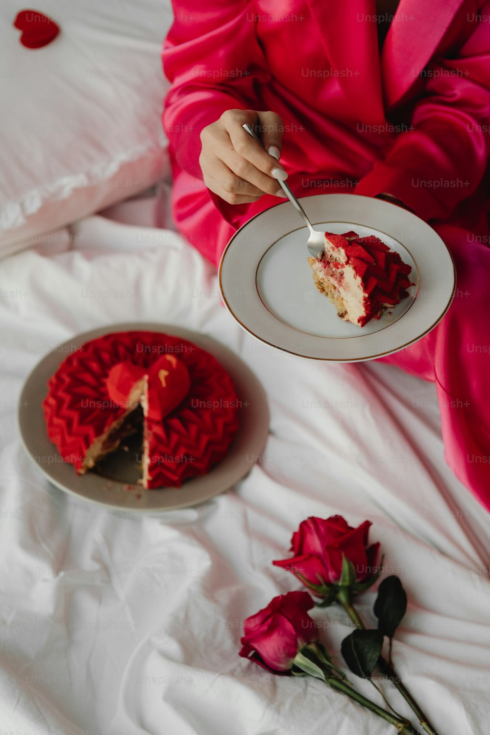 a woman in a red robe is eating a piece of cake