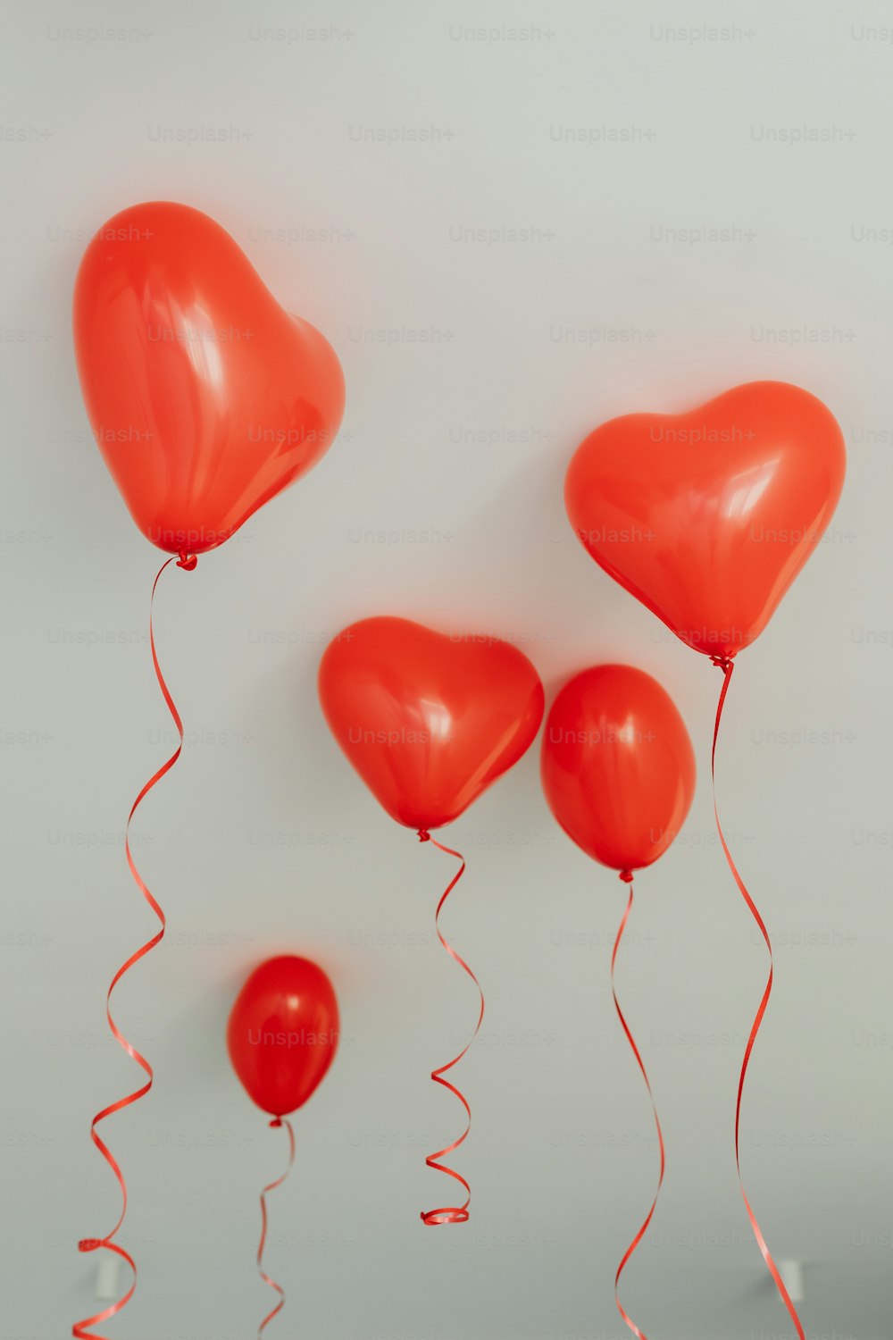a group of red balloons floating in the air