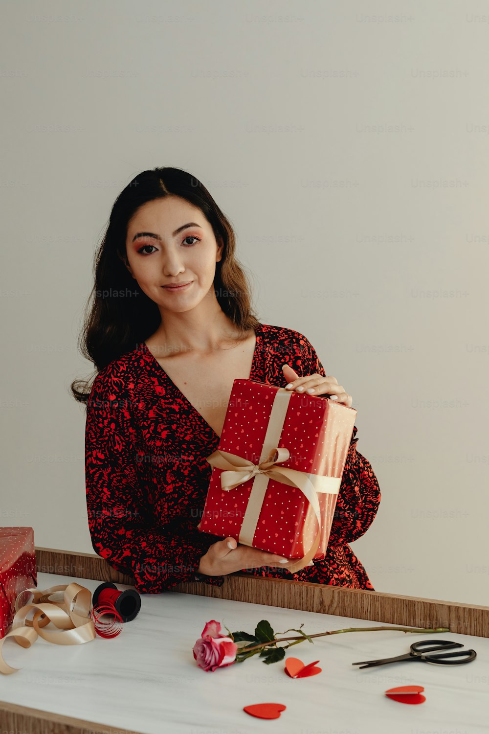a woman in a red dress holding a gift