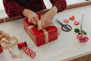 a woman is wrapping a gift on a table