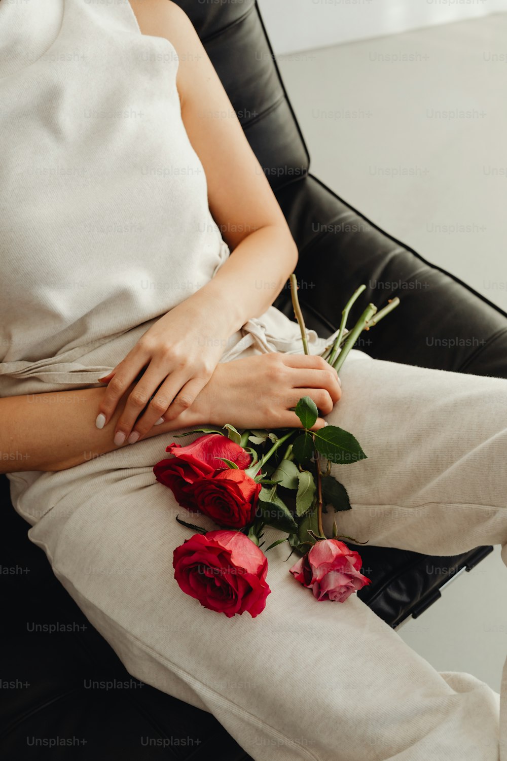 Una mujer sentada en una silla con un ramo de rosas