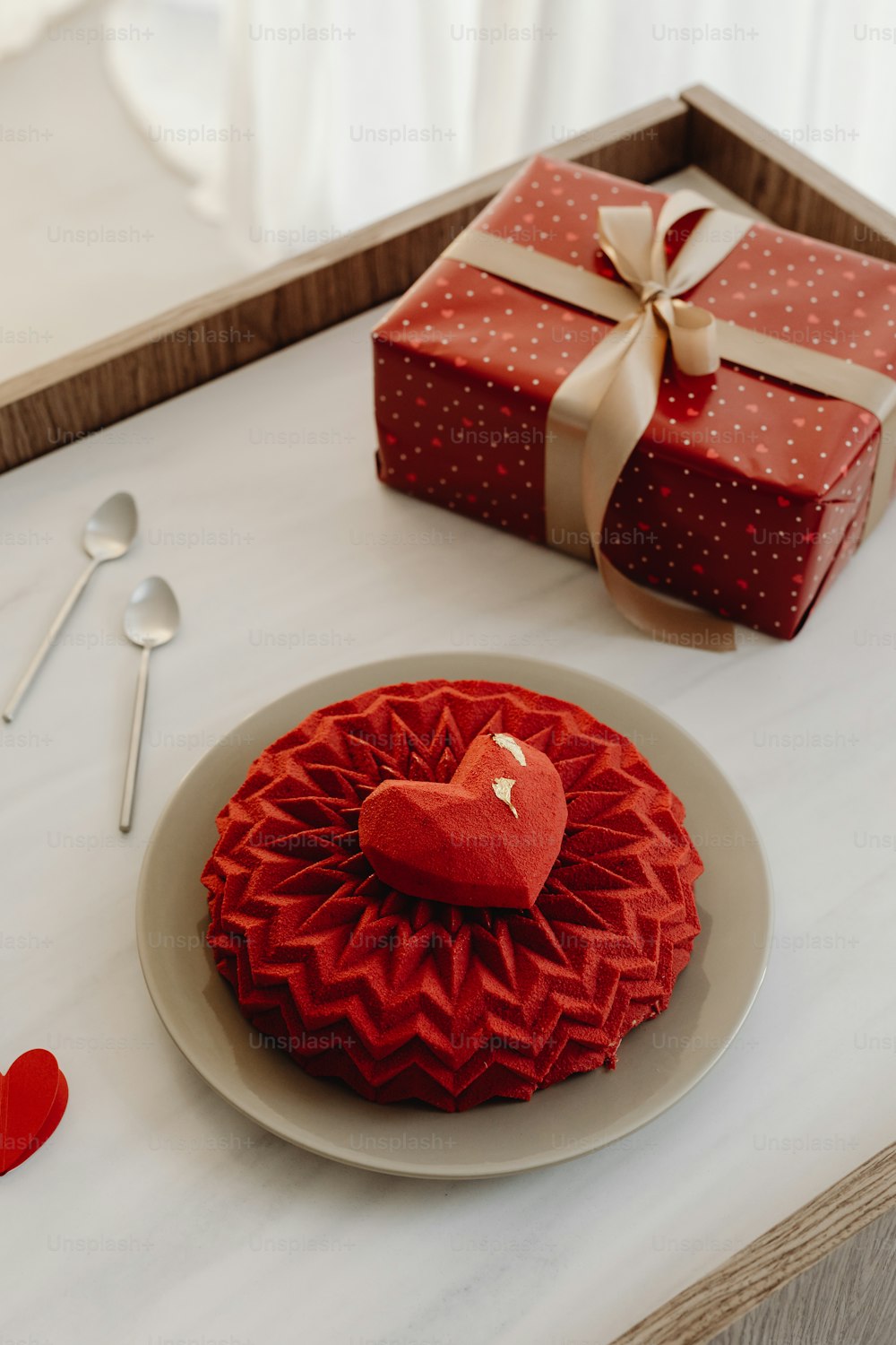 a red heart shaped cake sitting on top of a white plate