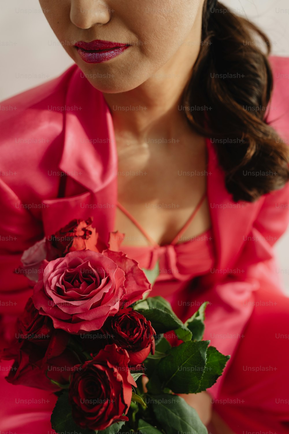 a woman in a red dress holding a bouquet of roses