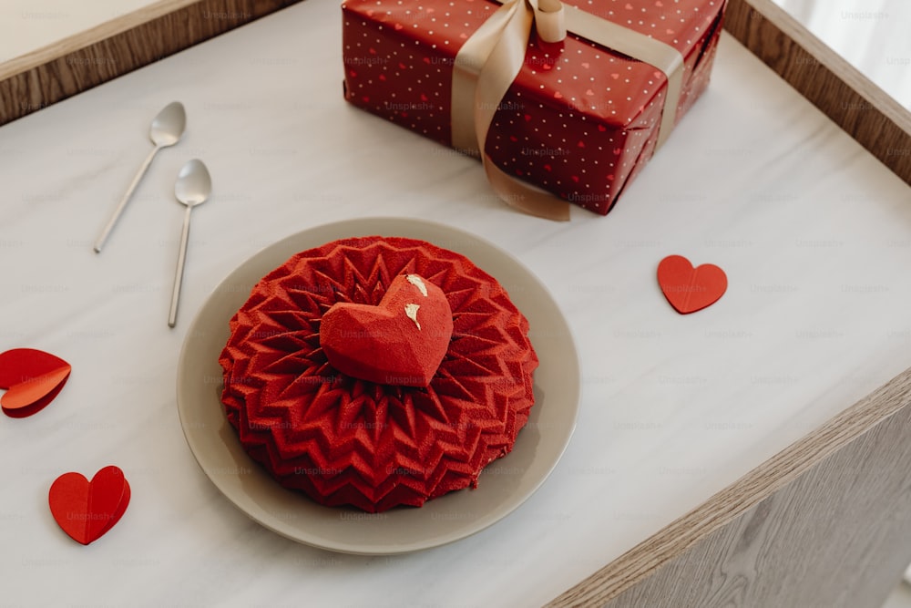 uma caixa vermelha em forma de coração sentada em cima de uma mesa