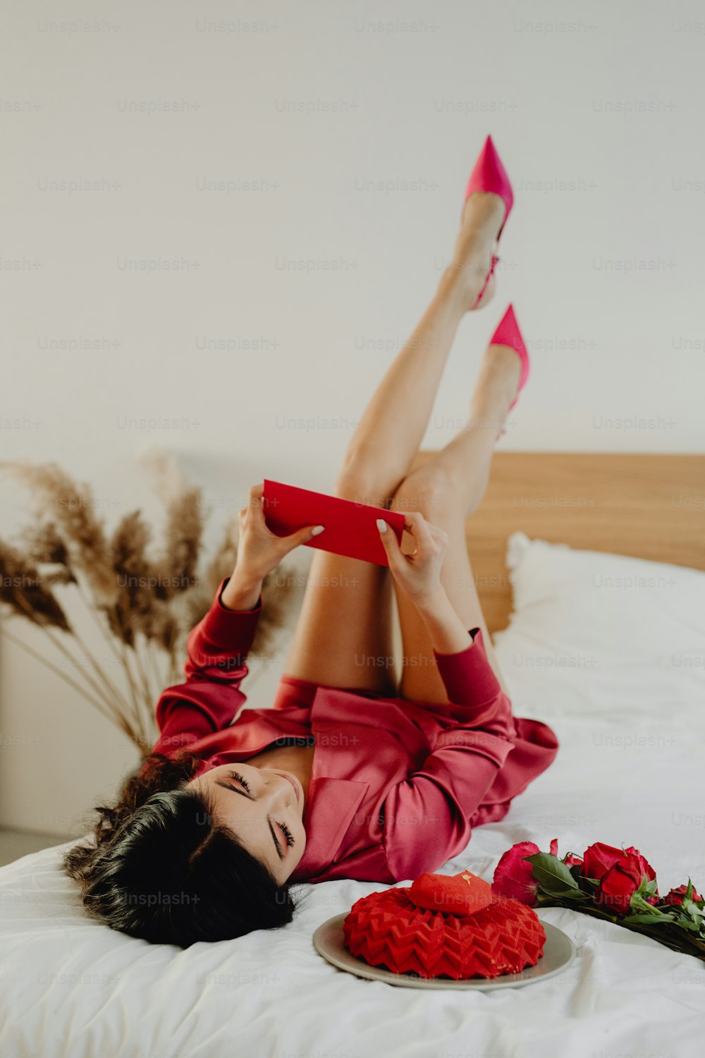 a woman laying on a bed with a cake