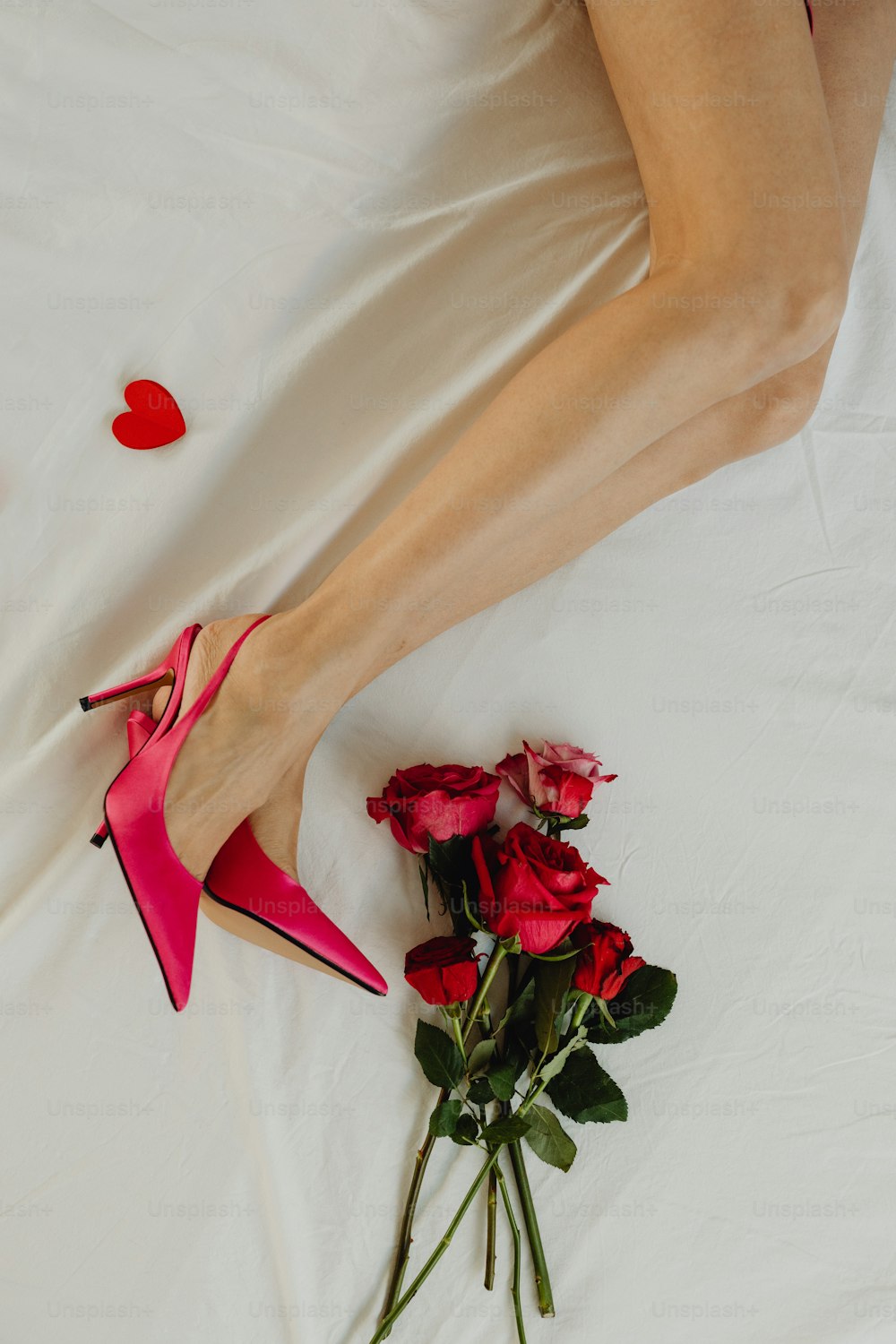 Eine Frau liegt mit einem Rosenstrauß auf einem Bett