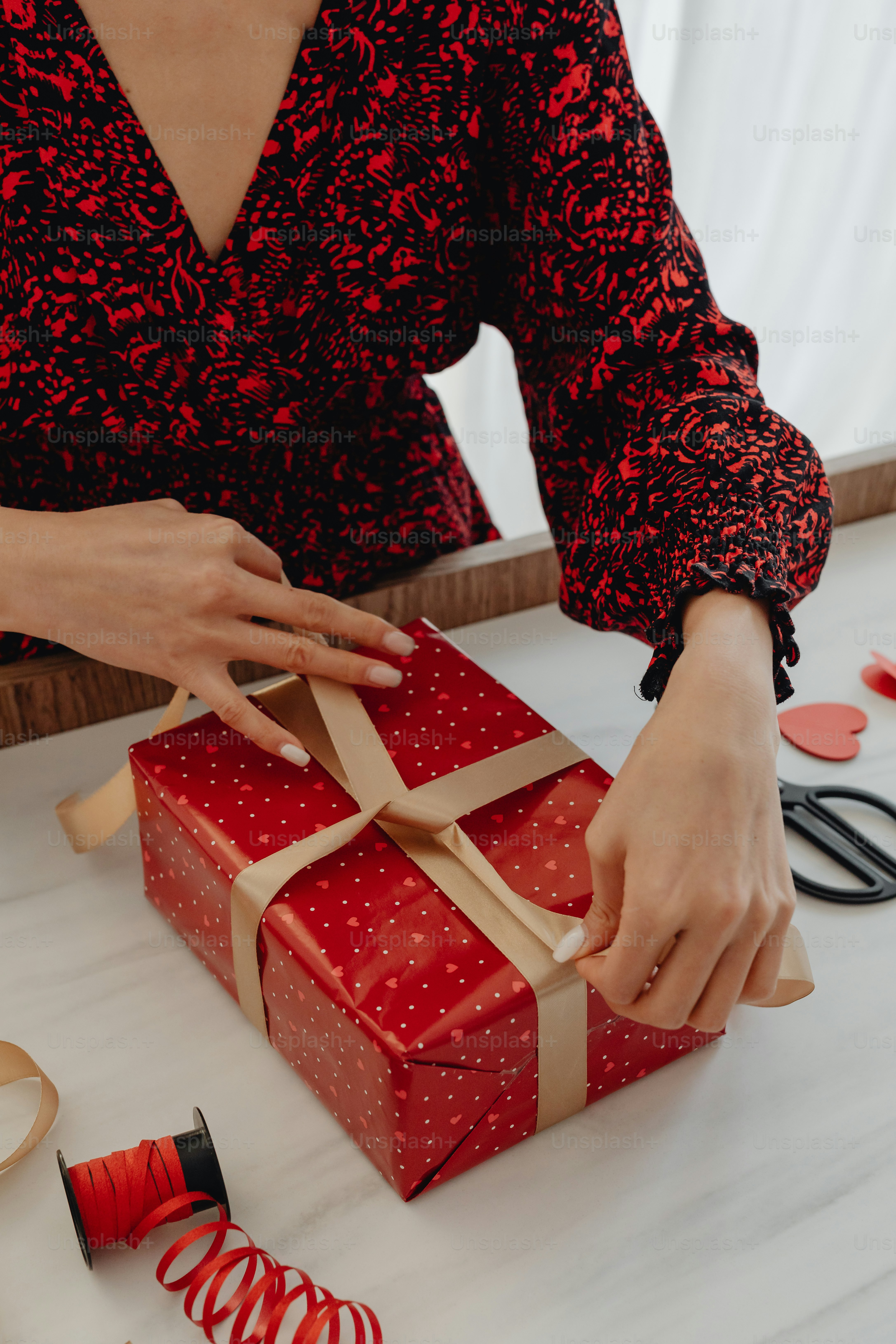 A woman is wrapping a red gift box photo – Love Image on Unsplash