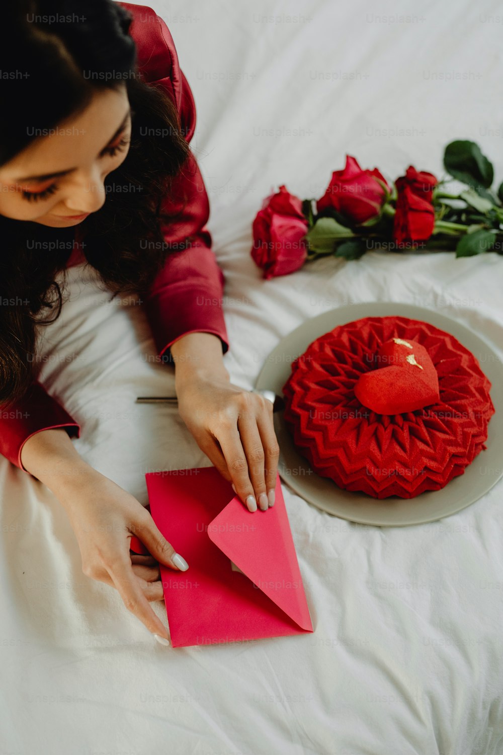 a woman cutting a red heart out of a piece of paper