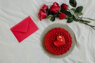 una galleta roja en forma de corazón junto a una rosa roja