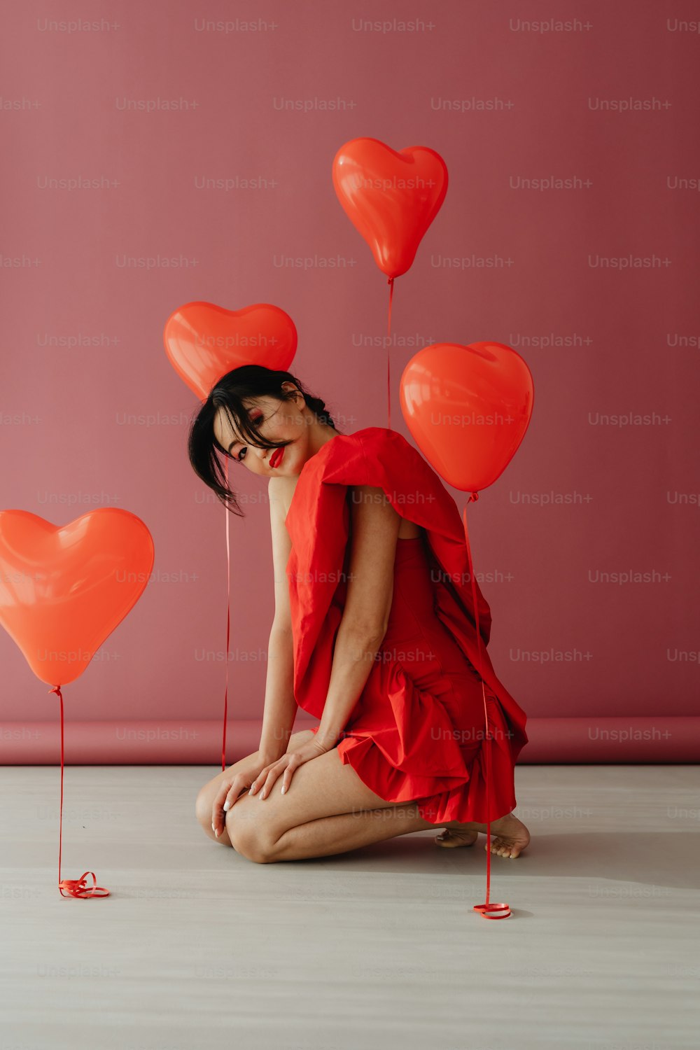 Eine Frau in einem roten Kleid sitzt auf dem Boden