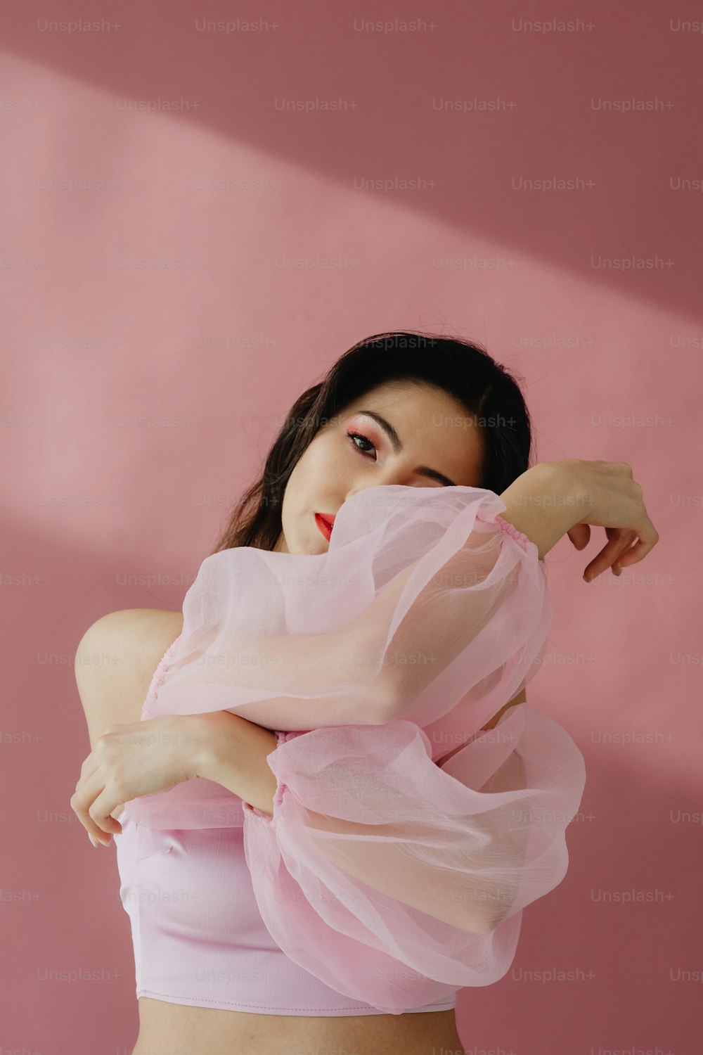 Una mujer con un top rosa posando para una foto