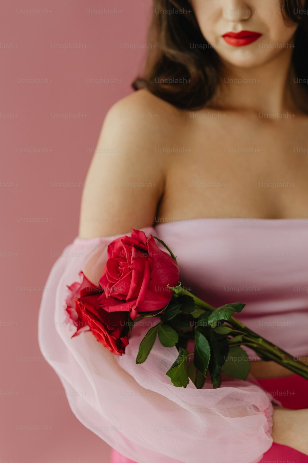 장미를 들고 분홍색 드레스를 입은 여자