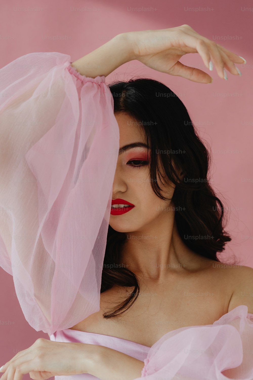 a woman in a pink dress with a veil over her head