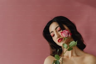 Eine Frau, die eine Rose vor ihr Gesicht hält