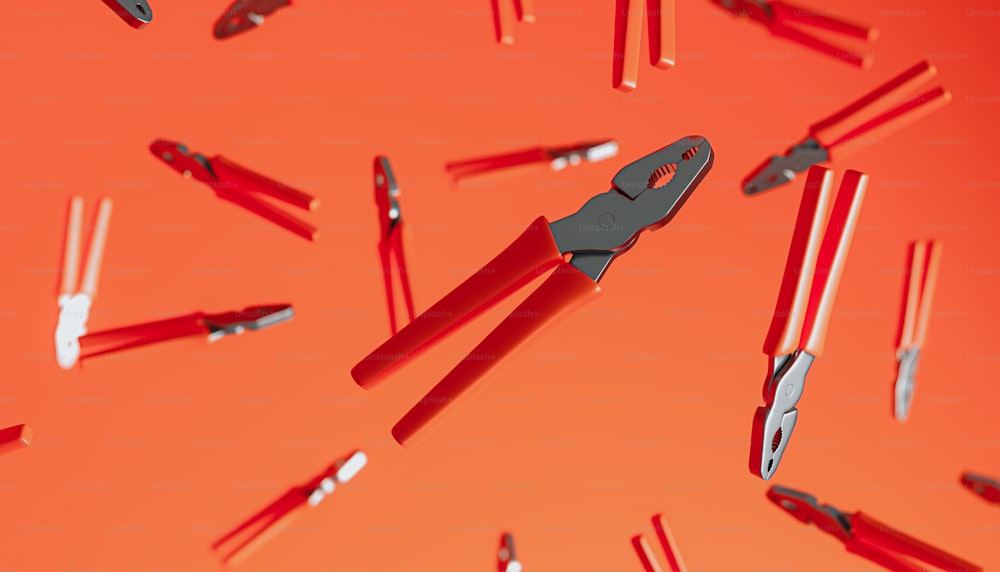 a group of red and black scissors on an orange background
