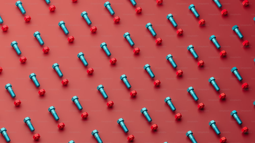 Un grupo de tornillos rojos y azules sobre un fondo rojo