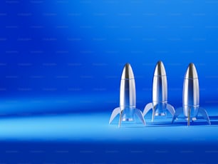 three silver bullet shaped objects on a blue background