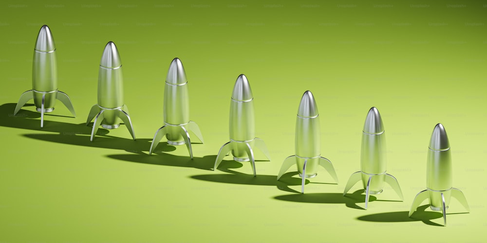a row of metal rockets sitting on top of a green surface