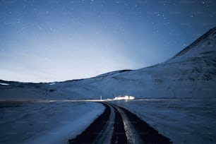 a snowy road with a mountain in the background