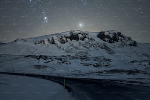 a mountain covered in snow under a night sky