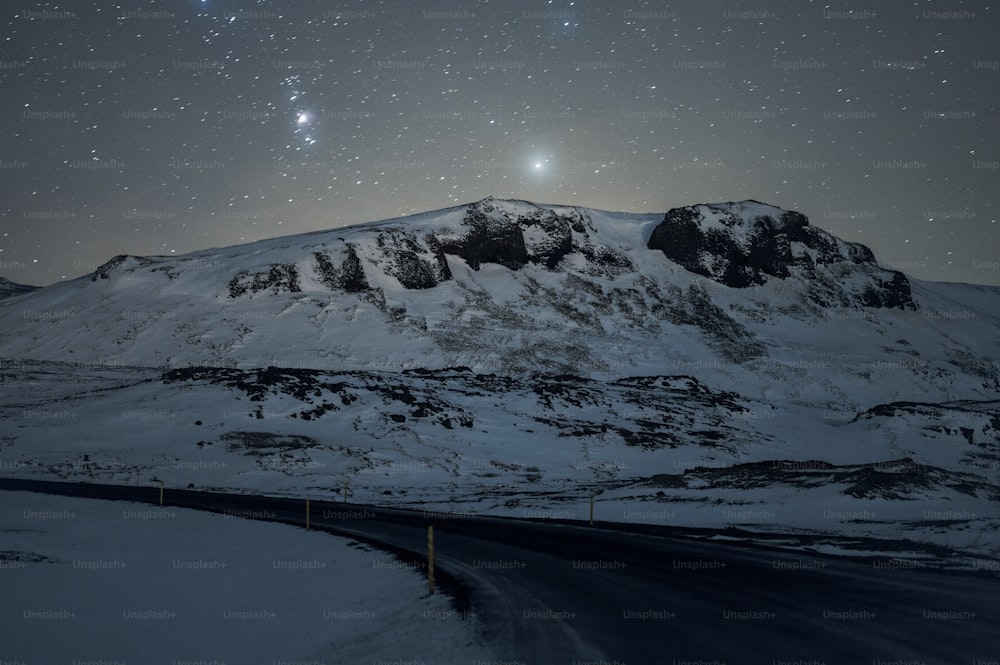 a mountain covered in snow under a night sky