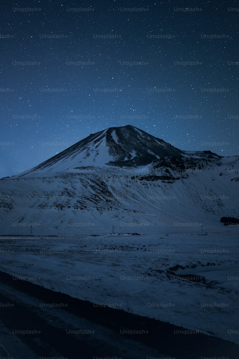 uma montanha coberta de neve sob um céu noturno