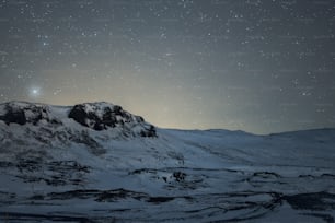 a mountain covered in snow under a night sky