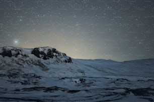 Una montagna coperta di neve sotto un cielo notturno