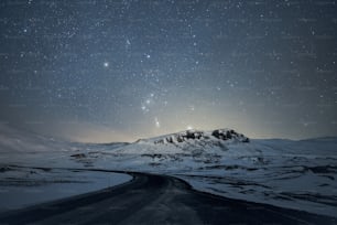 the night sky over a snowy mountain range