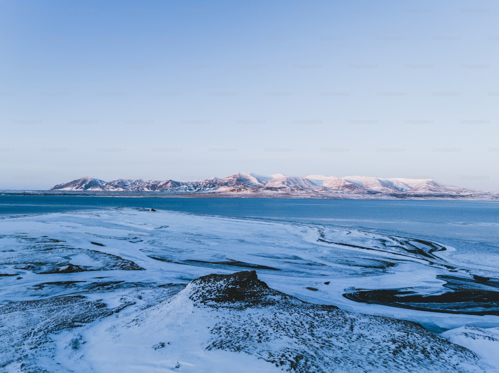 a large body of water surrounded by snow covered mountains