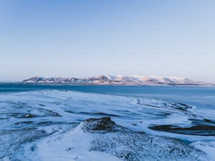 a large body of water surrounded by snow covered mountains