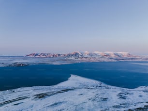 a large body of water surrounded by snow covered mountains