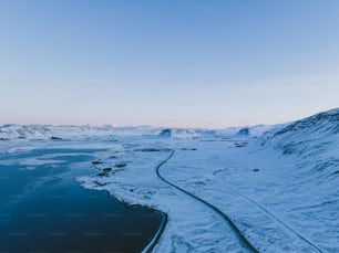 eine verschneite Landschaft mit einem Fluss, der durch sie fließt