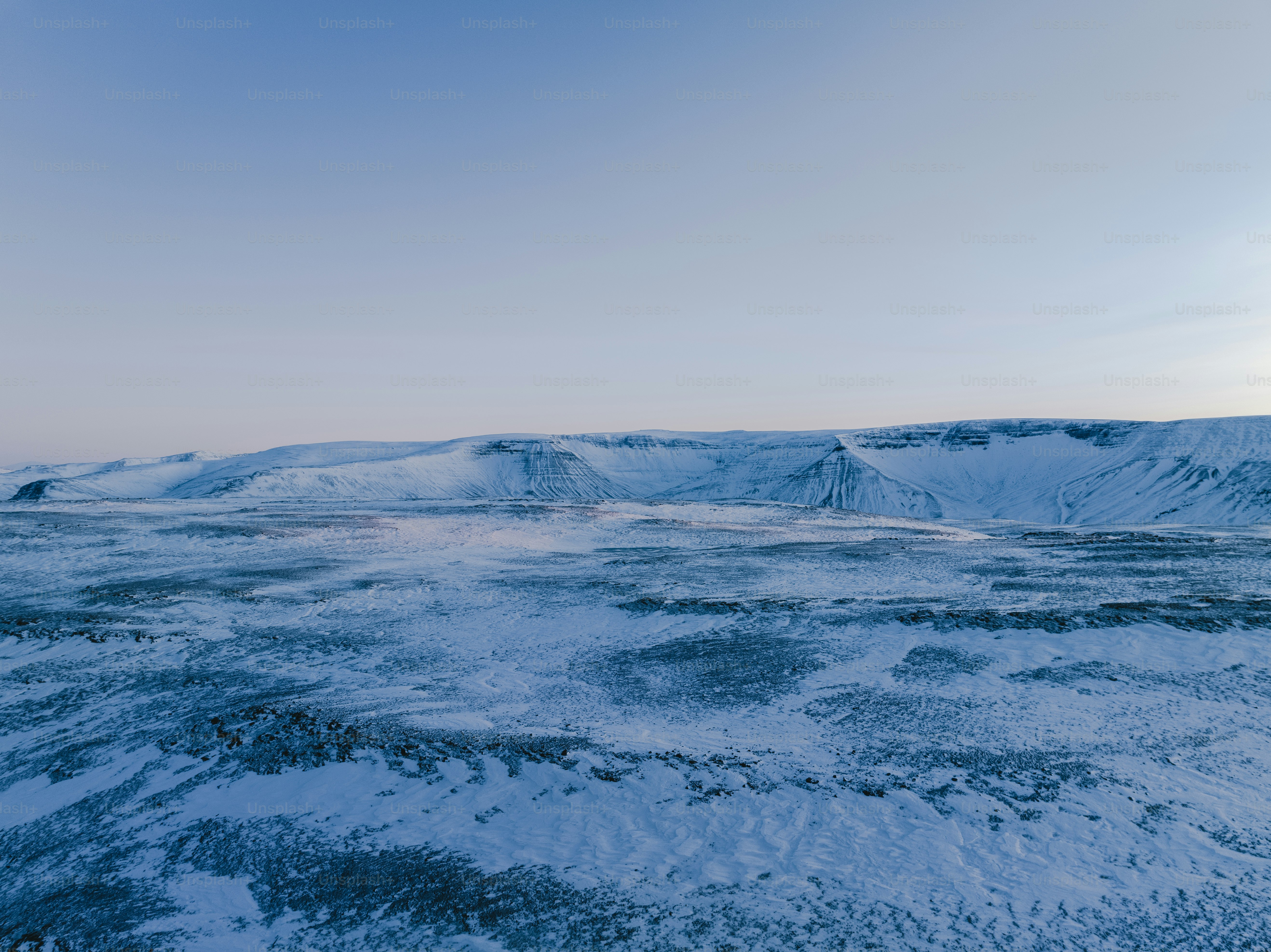 a snow covered landscape with mountains in the distance