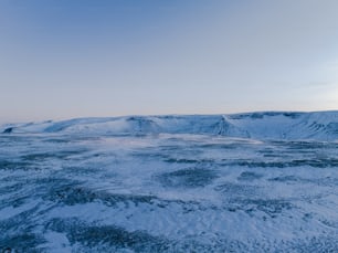 a snow covered landscape with mountains in the distance