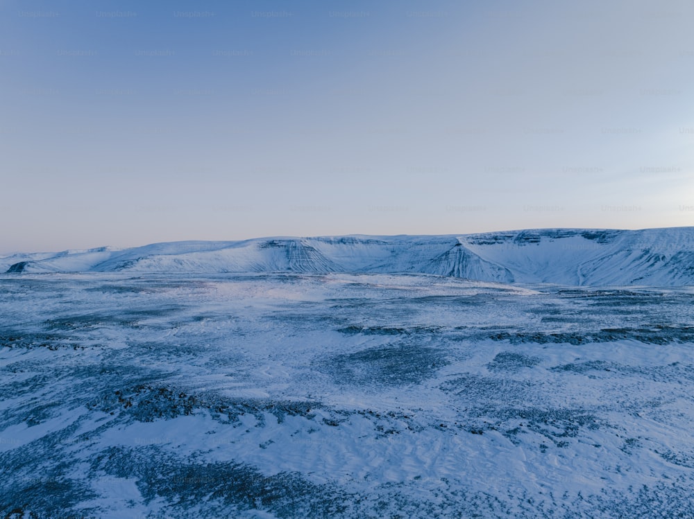 a snow covered landscape with mountains in the distance