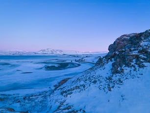 a snowy landscape with a mountain in the background