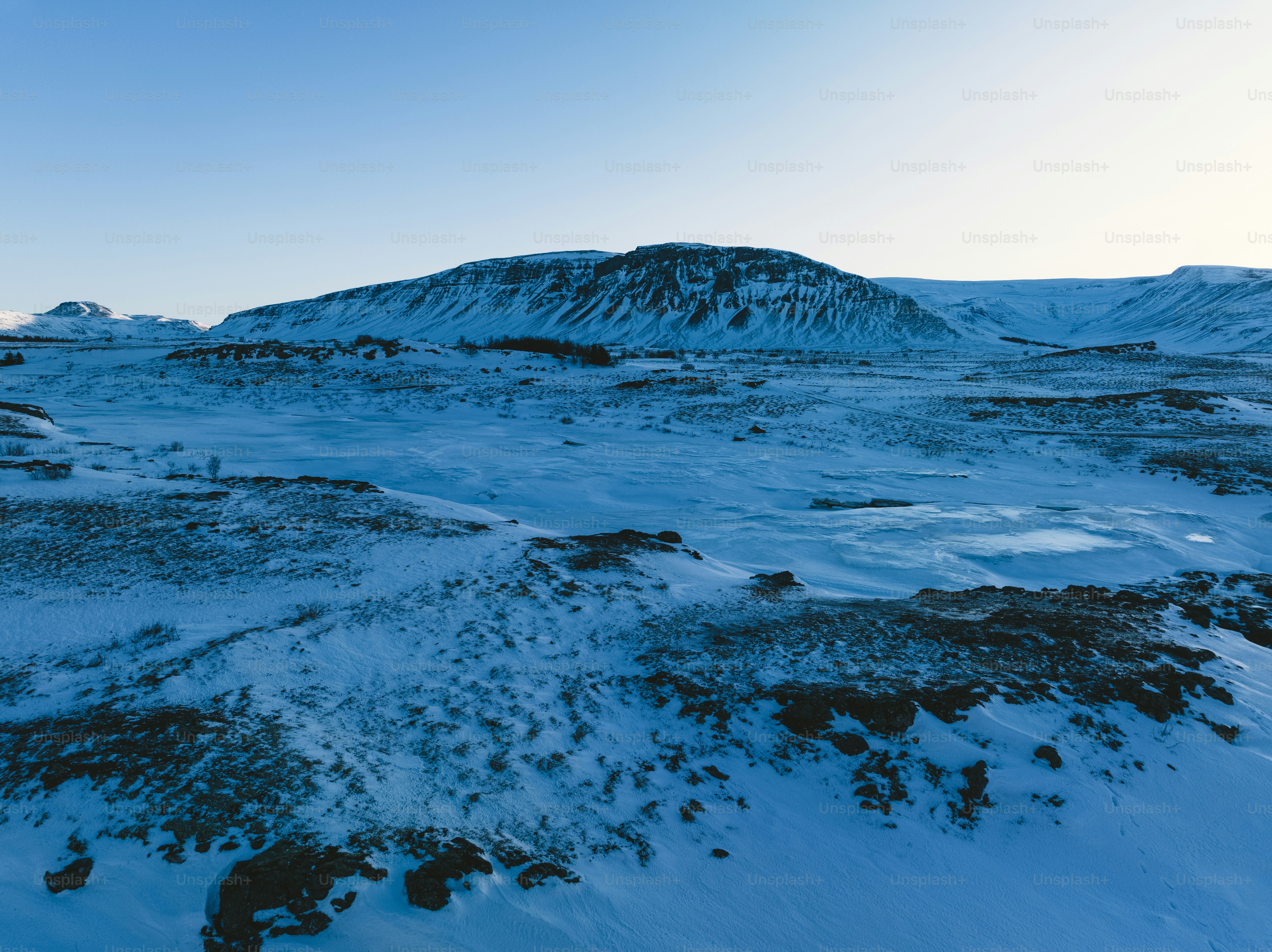 a snowy landscape with a mountain in the background
