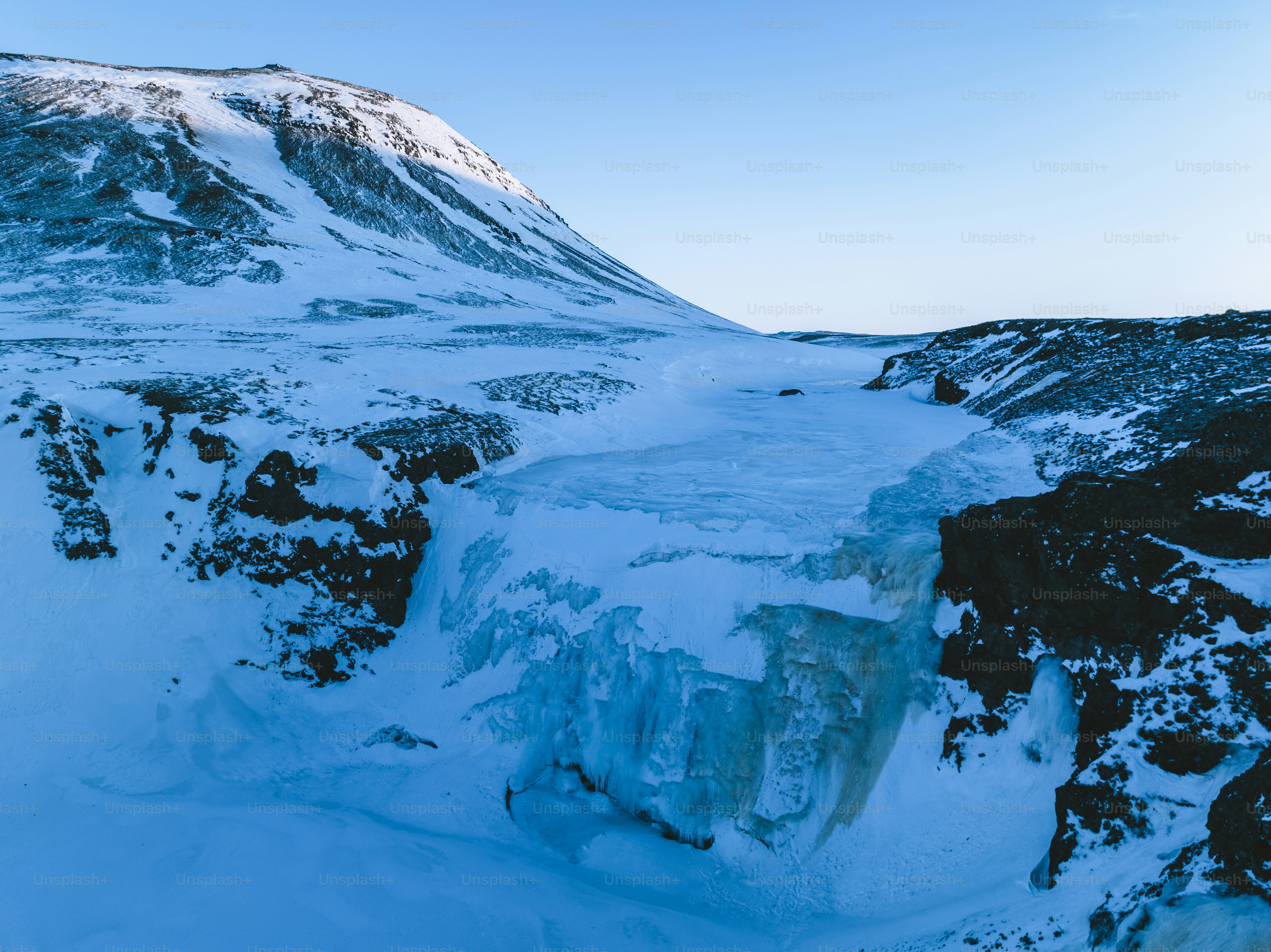 Una montaña cubierta de nieve con una montaña muy alta al fondo