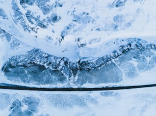 an aerial view of snow covered mountains and a river