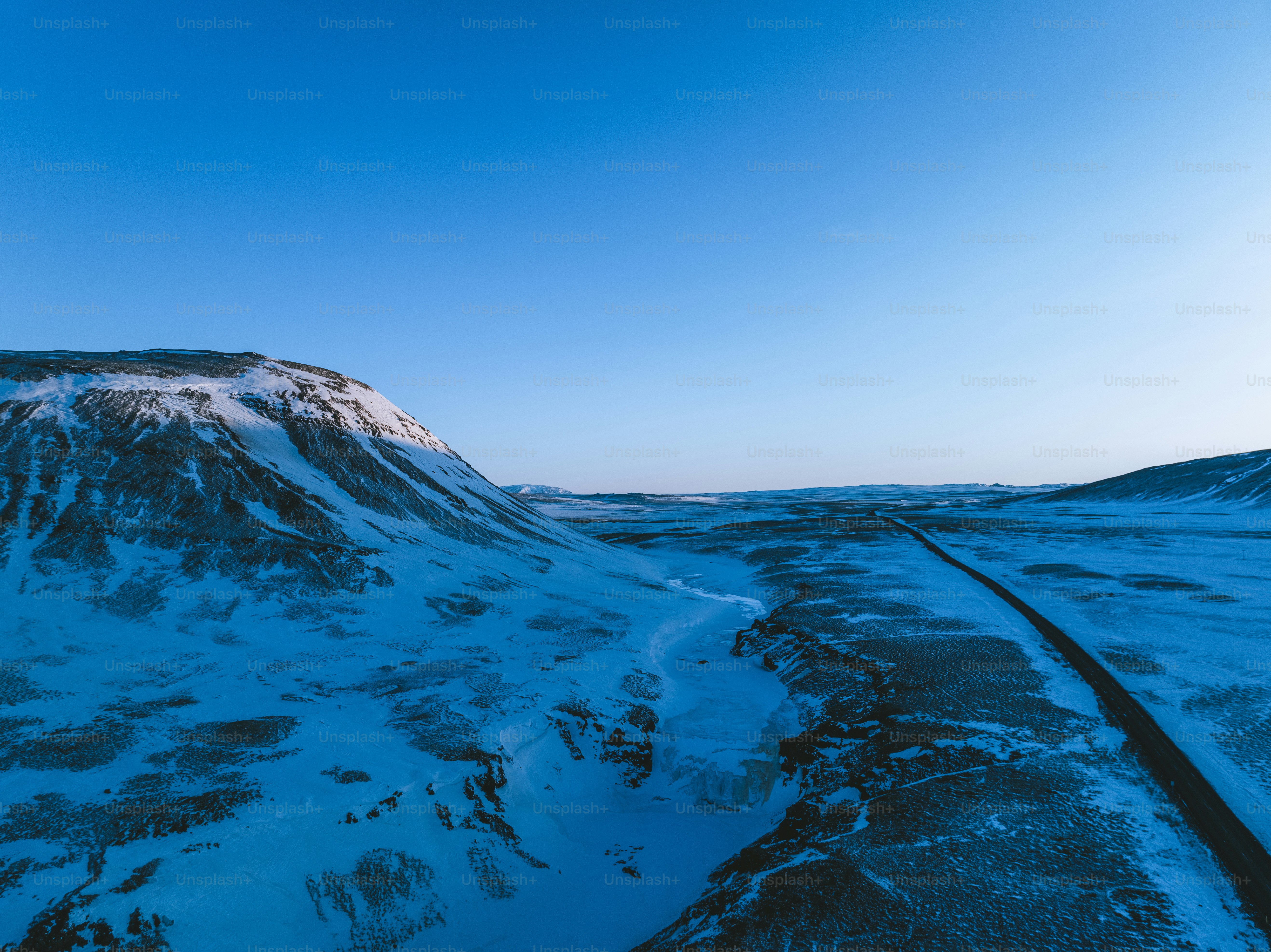 a snow covered mountain with a train track running through it