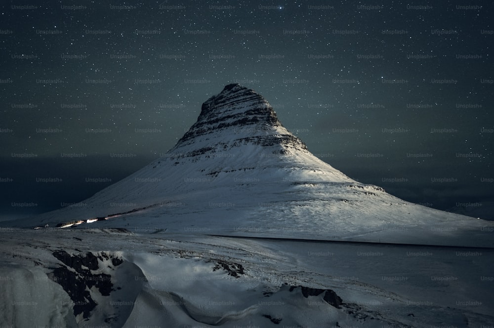 Una montagna coperta di neve sotto un cielo notturno