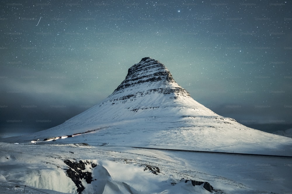 Una montaña cubierta de nieve bajo un cielo lleno de estrellas