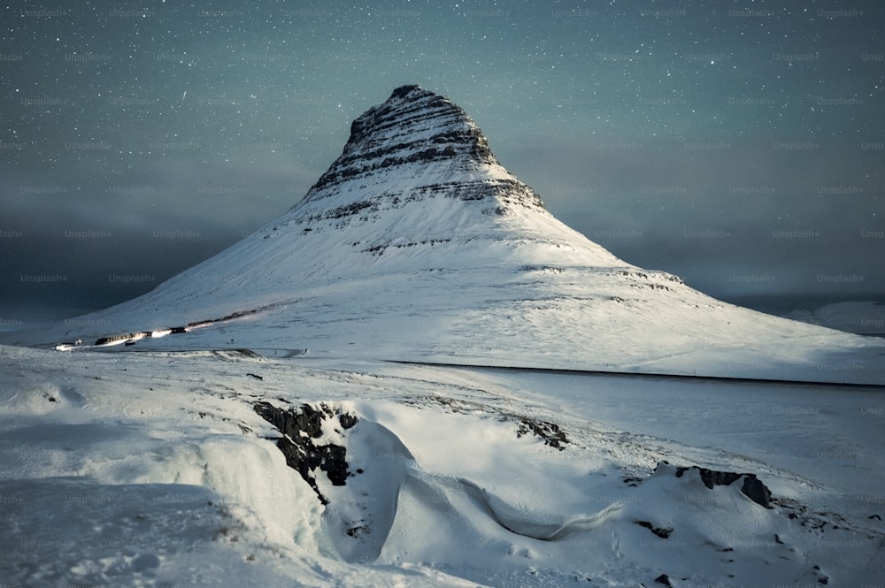 a snow covered mountain under a night sky